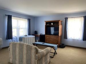 a living room with a couch and a flat screen tv at The Lakes at Ben Eoin Golf Club & Resort in Big Pond