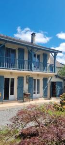 a large house with blue doors and a balcony at Chambres d hôtes Avalanche du rock in Buzy