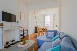 a living room with a blue couch and a fireplace at Suite Number 14 in Liévin