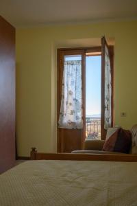 a bedroom with a bed and a window at Sonia House Discover Tuscany in Torniella