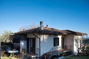a small white house with a porch at Sonia House Discover Tuscany in Torniella