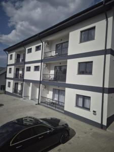a black car parked in front of a building at Apartament 3D in Fălticeni