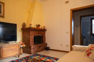 a living room with a fireplace and a flat screen tv at Sonia House Discover Tuscany in Torniella