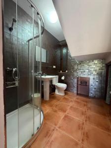 a bathroom with a shower and a toilet and a sink at Casa, al lado de las playas in Cee +33 photos