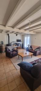 a living room with couches and a coffee table at Chambres d hôtes Avalanche du rock in Buzy