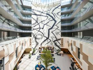 an aerial view of the lobby of a building with a mural at Mercure Geneva Airport in Geneva