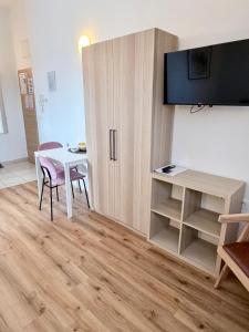 a room with a table and a cabinet with a television at Lucky center Ljubljana in Ljubljana