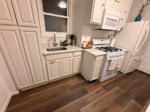 a kitchen with white cabinets and a stove and refrigerator at Spacious 2BR Getaway Easy Access to NYC & Newark in Kearny +14 photos