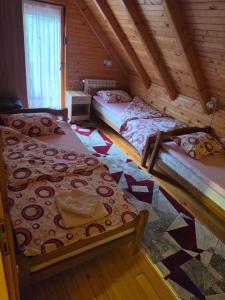 a room with three beds in a log cabin at Guest house Anka in Žabljak