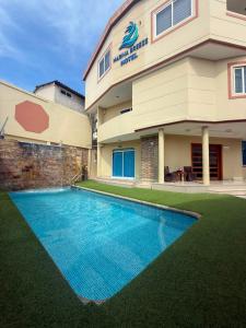 a hotel with a swimming pool in front of a building at Marina Breeze hotel in Manta