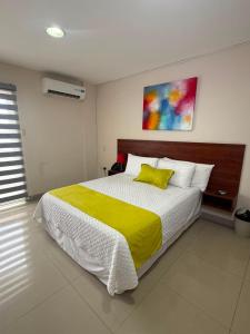 a bedroom with a large bed with a yellow blanket at Marina Breeze hotel in Manta