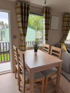 a wooden table and chairs in a living room at 10 the green lilliardsedge carvan park harritsfield jedbrugh td8 6tz in Harrietsfield +19 photos