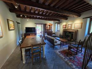 a living room with a table and a fireplace at Casale Montone , villa with private pool in Montone