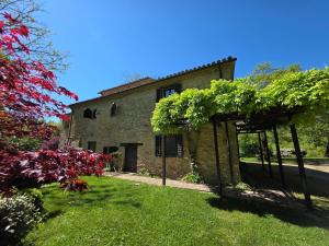 an old stone house with green plants on a yard at Casale Montone , villa with private pool in Montone