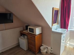 a bathroom with a sink and a microwave on a dresser at Station View Guest House in Dyce +38 photos
