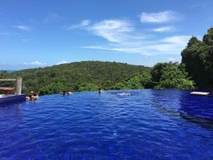 a group of people swimming in a blue pool at Villas do Pratagy VIP in Maceió +10 photos