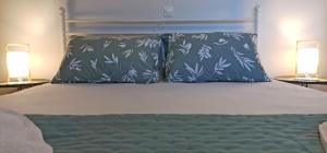 a bed with two pillows on it with two lamps at Lemon Tree Apartment with Garden in Chios