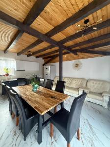 a dining room with a wooden table and black chairs at Complex Turistic Hor'A in Slănic