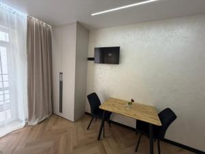 a dining room with a table and a refrigerator at Поляна Апарт in Polyana
