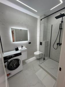 a bathroom with a washing machine and a shower at Поляна Апарт in Polyana