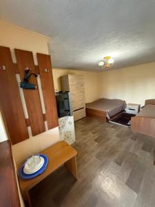 a small living room with a bed and a table at Садиба «Під ліском» in Pulʼmo