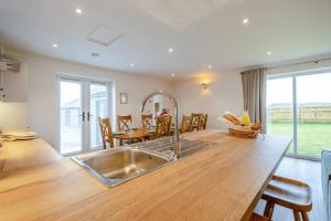 a kitchen with a stainless steel sink and a table at 4 Bed in Otterden oc-d36009 in Otterden