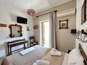 a bedroom with a bed and a desk and a mirror at Haus Niko Apartments and Suites in Nea Potidaea