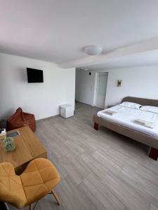 a large bedroom with a bed and a table at Born by the sea in Vama Veche