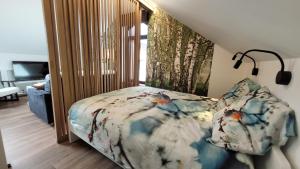 a bedroom with a bed with a floral cover at Studio 4 pers avec balcon et jardin in Sprimont