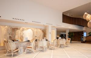 a lobby with a row of chairs and a counter at Kimpton Aysla Mallorca by IHG in Santa Ponsa