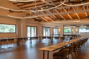 a large room with wooden tables and chairs at Kimpton Aysla Mallorca by IHG in Santa Ponsa +249 photos
