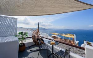 a balcony with a hammock and a view of the ocean at Sophia Oia View in Oia