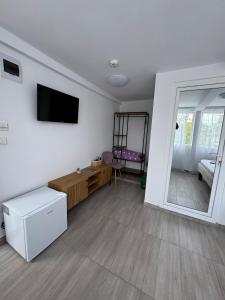 a living room with a tv on a wall at Born by the sea in Vama Veche +33 photos