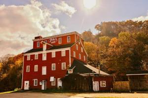 a large red brick building next to a barn at Riverbend Suite - Potter’s Mill in Bellevue