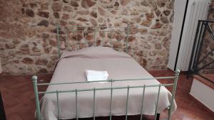 a small bed in a room with a stone wall at casa carmela in Bolognetta