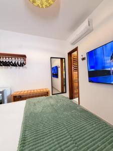 a bedroom with a bed and a flat screen tv at Pousada Amazing Jeri in Jericoacoara