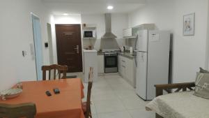 a kitchen with a table and a white refrigerator at Dpto tte ibañez in Cipolletti