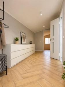 an empty living room with wood floors and a white dresser at ZWIN Apartment 4 in Skole