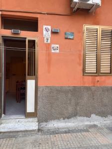 an orange building with a door and a table at La Dimora di Zia Rosa in Crotone