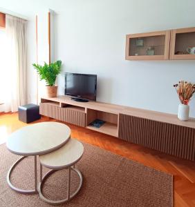 a living room with a table and a tv at Viveiro Centro con Vistas in Viveiro