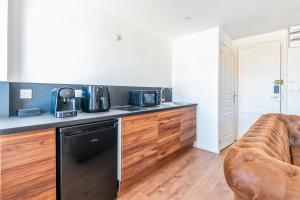 a kitchen with a counter and a couch in a room at Rockefeller - Le petit Loft New-Yorkais 5 Min de la plage in Dunkerque +6 photos