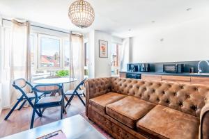 a living room with a couch and a table at Rockefeller - Le petit Loft New-Yorkais 5 Min de la plage in Dunkerque