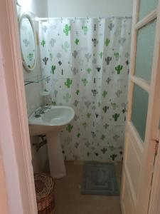 a bathroom with a sink and a shower curtain covered in clovers at LosCardones in Cafayate