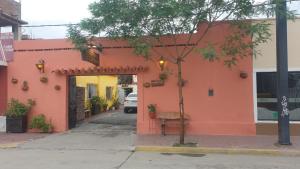 an orange building with a tree in front of it at LosCardones in Cafayate