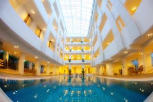 uma grande piscina num edifício com tecto em Trang Hotel Bangkok - SHA Plus em Bangkok