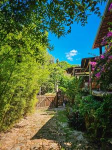 a path leading to a house with flowers at Canto Verde Pousada in Lençóis