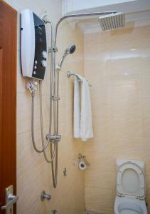 a bathroom with a shower with a toilet and a phone at Delfirm Hotel in Nairobi +48 photos