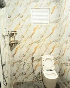 a bathroom with a toilet and a window at Paragone Home Stay Modern 3BR Apartment Style Home AC 5 Min to Enderamulla Station 15 Minute Train Ride to Colombo in Wattala +13 photos