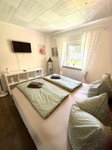 a bedroom with two beds and a tv on the ceiling at Lütte Butze in Marne