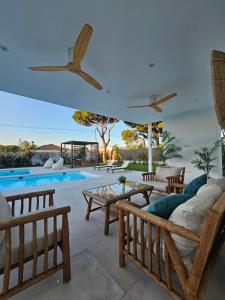 a villa with a swimming pool and wooden furniture at Casa Robert in Conil de la Frontera